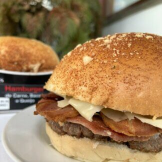 Hamburguer de Carne, Bacon e Queijo em primeiro plano e embalagem no fundo